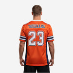 Right side view of custom orange and navy football jersey showing 3-stripe sleeve cuff detail and navy side panel seam on male model