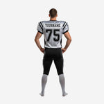 Opposite side view of white and black tackle football uniform showing diagonal black shoulder panel and pant stripe detail