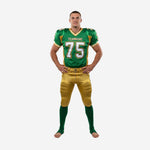 Custom american football team uniforms in kelly green and gold with V-neck collar, gold shoulder panels, and bold front number 75 on a male player, front view