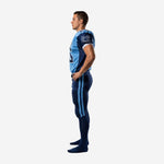 Right side view of custom blue and navy american football uniform with navy side panel on jersey and sky-blue pant stripes visible from hip to ankle