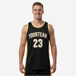 Custom black and gold basketball jerseys with arched team name, front number, and gold side panels shown on male model front view
