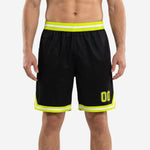Custom black and gold basketball shorts front and back view showing neon yellow chevron hem, double side stripe, and ribbed elastic waistband