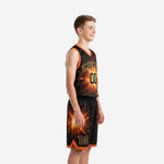 Side view of black and gold youth basketball uniform showing continuous spark pattern across jersey and shorts with orange V-notch hem split