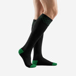 Side view of black and green soccer socks showing over the calf length and Kelly Green heel cup accent