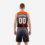 Left side view of black and orange custom basketball jersey and shorts set with orange waistband and continuous lightning pattern across the shorts leg