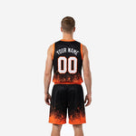Back view of black and orange basketball uniform showing player name arc and back number on pixel-scatter gradient jersey