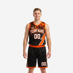 Custom black and orange basketball uniforms for club teams showing lightning bolt jersey and matching shorts front view
