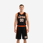Custom black and orange basketball uniforms two-piece set with orange V-neck binding, arced team name on chest, and number 00, worn by adult male model - front view