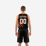 Opposite side view of custom black and orange basketball uniform set showing shorts side panel detail and hem length