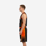 Opposite side view of custom black and orange basketball uniform set showing orange side panel detail on jersey and shorts worn by adult male model