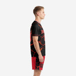 Black and red soccer uniforms left side view showing lava-crack pattern across jersey and red shorts with black side panels