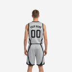 Opposite side view of black and white reversible basketball uniform displaying black trim on silver-grey reverse side with matching shorts side panels