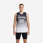 Black and white sublimation basketball jersey with charcoal-to-white hexagonal fade pattern, team name arced on chest, front and back view on male model