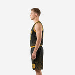 Side view of custom black basketball uniform showing gold armhole binding and damask pattern across jersey and shorts panels