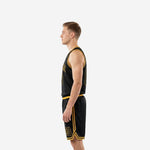 Side view of custom black basketball uniform showing gold side stripe on shorts and gold armhole binding on sleeveless black jersey