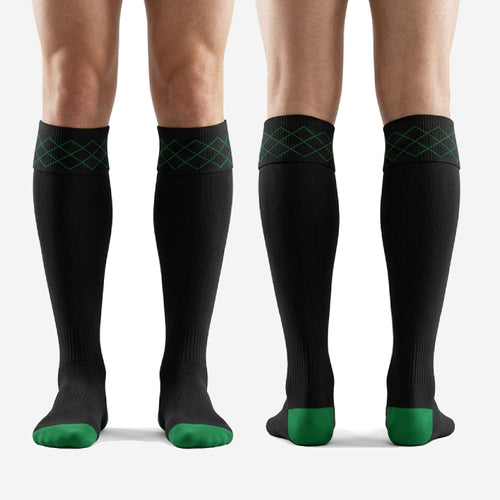 Full length view of custom black and green geometric soccer socks worn by adult male player