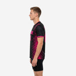 Full roster view of custom black soccer training jerseys in black and hot pink colorway showing team name and player number placement