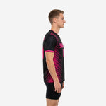 Closeup of black and hot pink sublimated soccer training jersey showing diagonal stripe print construction and fabric quality