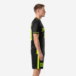 Black and neon green sublimated soccer kit side view showing stripe detail on jersey and shorts
