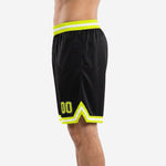 Right side view of black custom basketball shorts showing neon yellow side stripe and elastic drawcord waistband construction