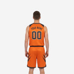 Other side view of reversible basketball uniform in charcoal base with orange diagonal brush-stroke shoulder and shorts panels