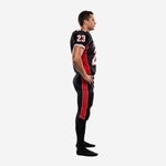 Black and red custom football uniform side view showing red curved jersey side panel and full-length red outer-leg pant stripe from hip to ankle