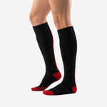 Angled view of custom red and black soccer socks displaying over-the-calf length and red heel cushion zone