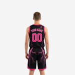 Opposite side view of black and pink reversible basketball uniforms showing the gradient fade from black at the shoulders to pink at the hem