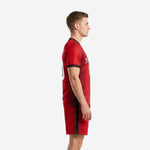 Left side view of men's red soccer uniform with black stripe pattern running from shoulder to shorts hem
