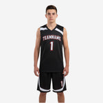 Black youth basketball uniforms front view showing V-neck jersey with white curved shoulder panels and red-outlined team name and number plus matching black shorts