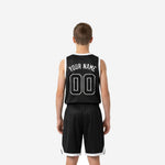 Opposite side view of black and white youth basketball uniform showing elastic waistband on matching shorts and sublimated pinstripe texture on jersey and shorts