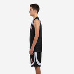 Side view of black youth basketball uniform set showing curved white arc panel on shorts leg and straight jersey side panel construction