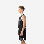Side view of black youth basketball uniform set showing white armhole binding on the sleeveless jersey and white V-notch hem trim on the basketball shorts