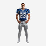 Blue and gold football uniforms front view showing royal-blue V-neck jersey with white shoulder panels, front number 23, team name arc, and silver-grey pants with blue side stripe