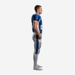 Side view of the blue and gold football uniform showing the set-in sleeve cuff binding, royal-blue jersey body, and the full-length blue outer stripe on silver-grey pants