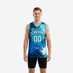 Blue and white basketball jerseys with teal-to-navy paint-splash sublimation print, team name arc and number 00 on front, adult male model