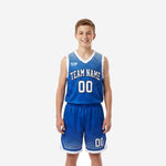 Custom blue and white youth basketball uniform front view showing royal blue halftone dot gradient jersey and matching shorts with white V-neck binding