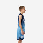 Youth player wearing custom blue and white basketball uniform with arced white team name and number on navy-to-sky-blue gradient jersey and sky-blue shorts