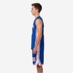 Opposite side view of custom blue and white youth basketball uniform showing contrast white panel and red accent stripe down jersey and shorts