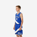 Left side view of royal blue and white youth basketball uniform set showing diagonal sash panel alignment on jersey and shorts