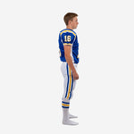 Side view of custom blue and white youth football uniforms showing back number placement royal blue shoulder panels and full-length blue and gold outer leg stripe on white pants