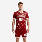 Bold crimson custom red and black soccer uniforms set front view showing geometric shatter-burst pattern on jersey and matching shorts