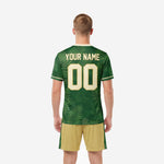 Forest green custom soccer jersey back view with cream player name and number over fern-leaf all-over print