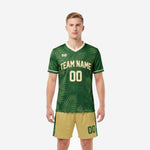 Bold forest green custom soccer uniform kit front view with fern-leaf botanical print and Vegas Gold shorts worn by adult male model