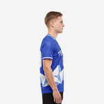 Bold Royal Blue custom men's soccer t shirts with geometric crystal pattern, left side view on adult male model