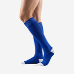 Bold royal blue custom soccer socks pair angle showing geometric diamond knit cuff detail and full calf coverage