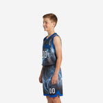 Left side view of youth boys basketball uniform set showing royal blue armhole binding and lightning storm shorts print