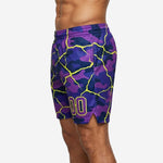 Side view of purple and yellow sublimated basketball team shorts showing elastic waistband, side split at hem, and all-over crackle-camo print