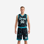 Bulk reversible basketball uniforms in black with teal geometric star-burst pattern and teal trim, front view of full set on adult male model