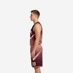Side view of burgundy galaxy basketball uniform showing diagonal comet streak running from jersey panel through shorts leg in cream and maroon